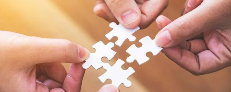 Plusieurs mains qui tiennent des morceaux de puzzle