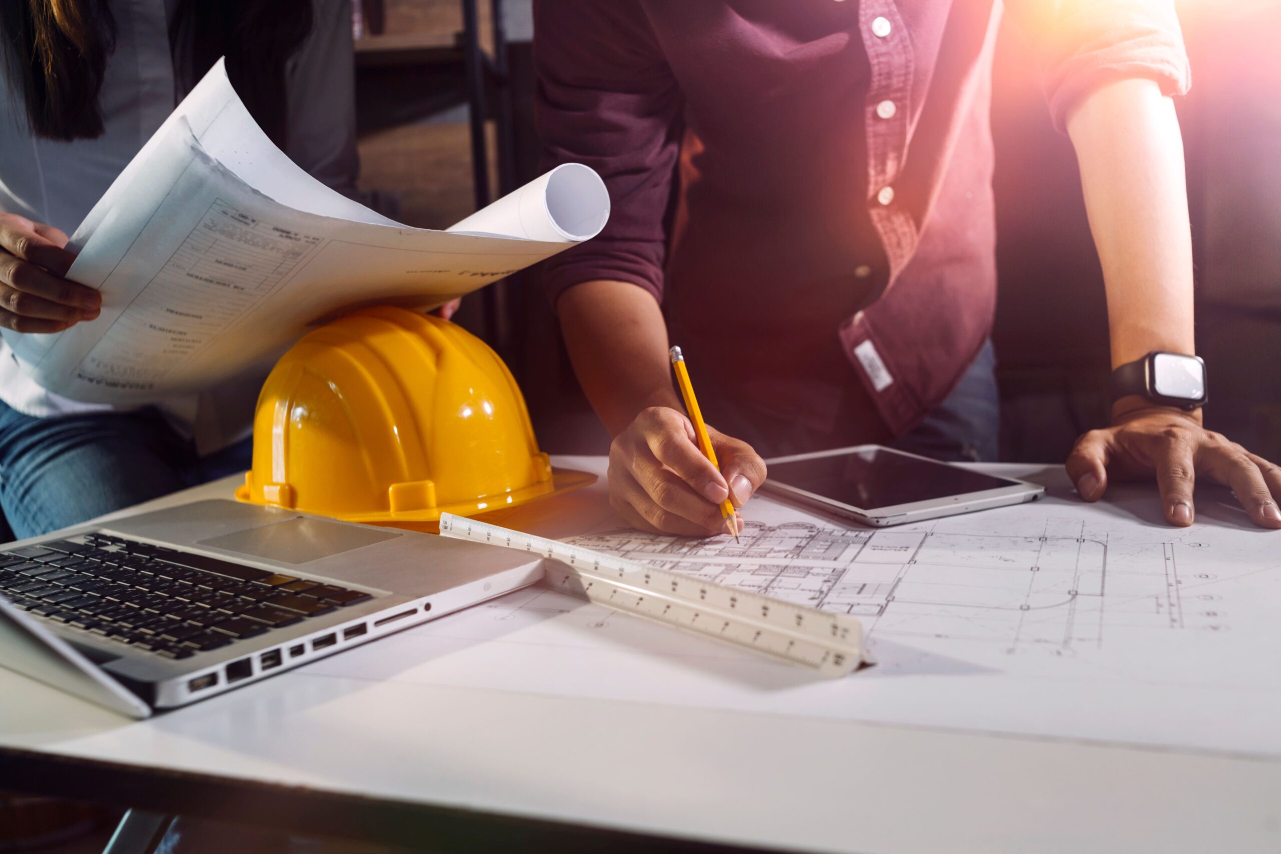Cartes et plans posé sur un bureau avec deux hommes qui travaillent